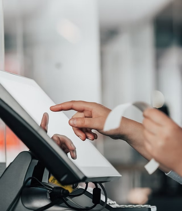 main d'un personne tapotant sur une caisse tactile 